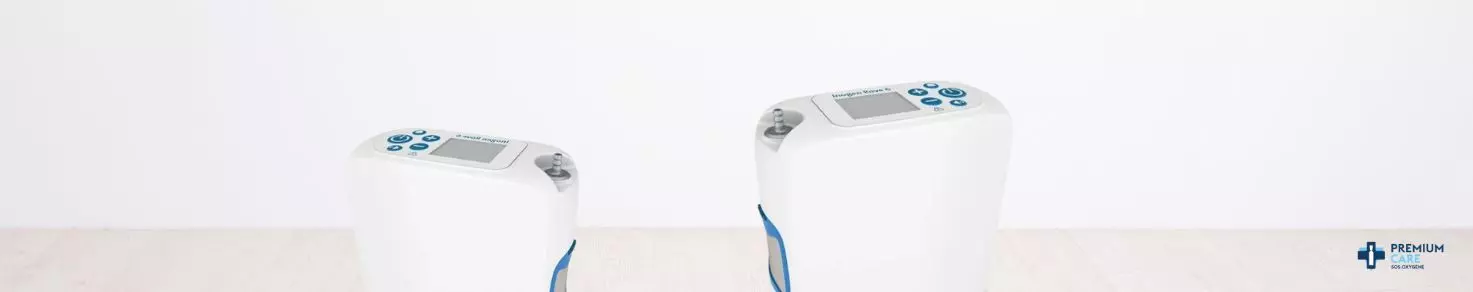 Un homme portant un masque PPC est allongé dans le lit, adossé à un oreiller, tandis qu'une femme à côté de lui sourit et regarde une tablette qu'ils tiennent ensemble.